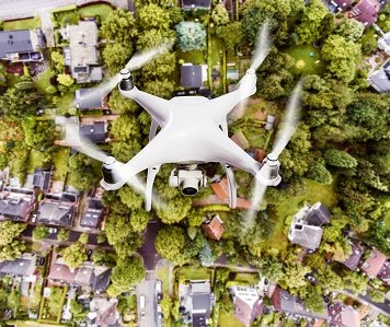 [Translate to Englisch:] Drohne mit Kamera über Dorf